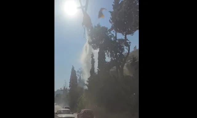 אכאיה: מסוק מטיל מים ליד כביש עם מכוניות - וידאו